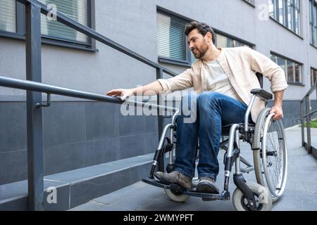 Jeune homme barbu aux cheveux foncés sur un fauteuil roulant Banque D'Images