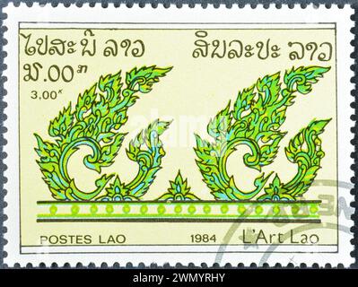 Timbre-poste annulé imprimé par le Laos, qui montre des feuilles, vers 1984. Banque D'Images
