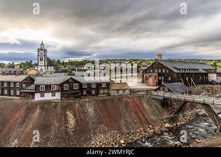 La lumière dorée baigne l'historique Roros avec son église proéminente et Smeltehytta, capturant le riche héritage minier de la ville dans un ciel spectaculaire Banque D'Images