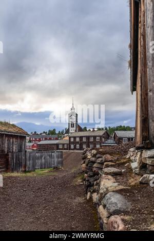 Dans cette perspective verticale, l'église de Roros se dresse au milieu des bâtiments historiques en bois, capturés depuis un chemin. Norway Banque D'Images