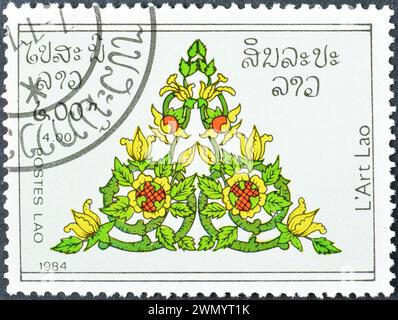 Timbre-poste annulé imprimé par le Laos, qui montre un motif floral, vers 1984. Banque D'Images