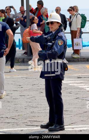 Une employée italienne de la circulation agite des véhicules en raison de la congestion du parking dans le port d'Amalfi pendant un jour férié occupé. Banque D'Images