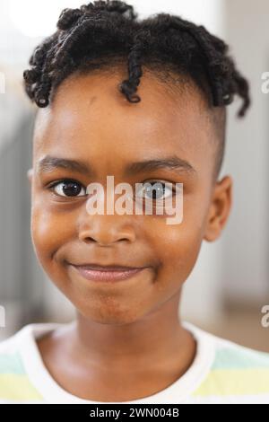 Garçon afro-américain avec un sourire joyeux, portant des tresses Banque D'Images