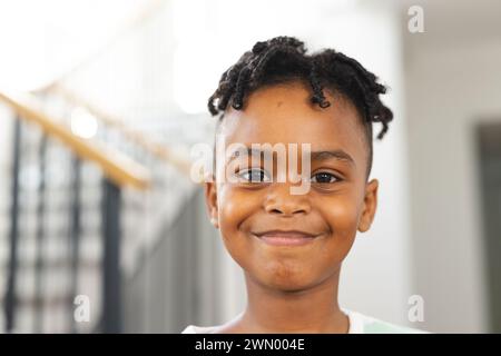 Garçon afro-américain avec un sourire joyeux, portant des tresses Banque D'Images