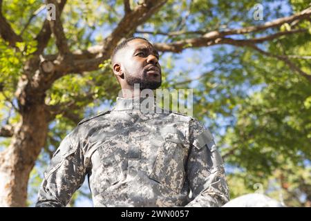 Homme afro-américain en uniforme militaire se tient confiant dehors Banque D'Images