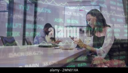 Image des données financières et des graphiques sur la femme biraciale au bureau Banque D'Images