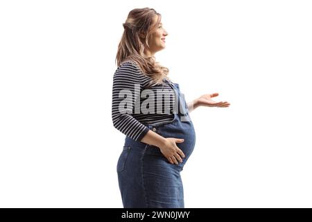 Plan de profil d'une jeune femme enceinte faisant des gestes avec la main isolée sur fond blanc Banque D'Images
