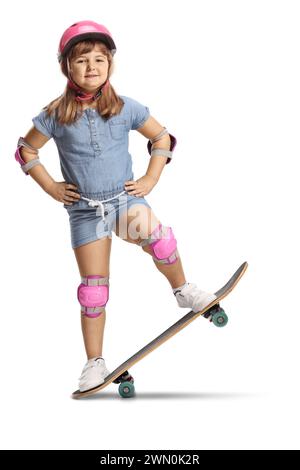 Fille debout sur une planche à roulettes avec coude et genouillères et casque isolé sur fond blanc Banque D'Images