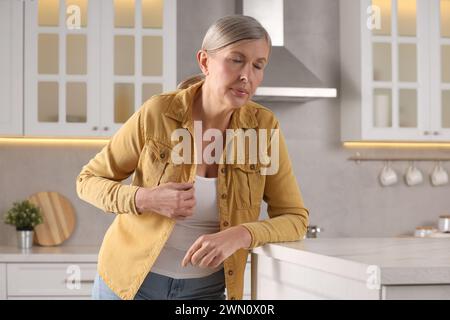 Ménopause. Femme souffrant de flash chaud dans la cuisine Banque D'Images