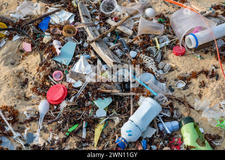 Koh Samui, Thaïlande - 19 janvier 2024 : une plage déserte, jonchée de bouteilles en plastique, d'emballages et d'autres déchets. Banque D'Images