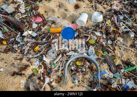 Koh Samui, Thaïlande - 19 janvier 2024 : une plage déserte, jonchée de bouteilles en plastique, d'emballages et d'autres déchets. Banque D'Images