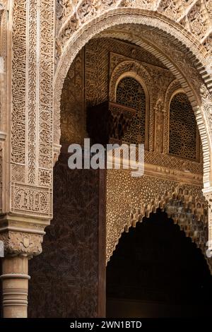 GRENADE, ESPAGNE : 24 MARS 2023 : lumières et ombres jouant avec les reliefs ornés des arches et des murs à l'intérieur du palais de l'Alhambra à Grenade, Spai Banque D'Images