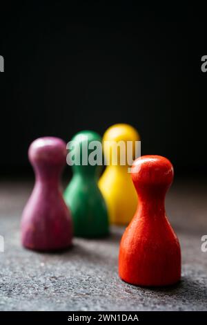 Trois pièces de jeu de style pion debout ensemble et un rouge à une distance d'eux. Banque D'Images