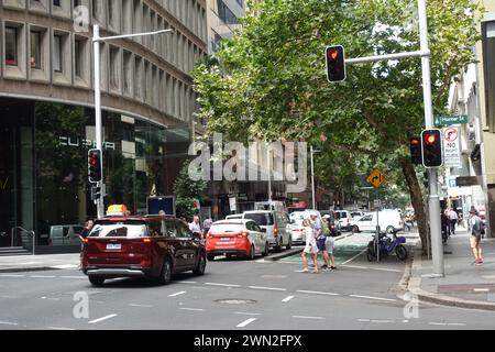 Dans le quartier des affaires de Sydney, une route très fréquentée est bordée de voitures tandis que les pistes cyclables adjacentes restent visiblement vides, ce qui met en évidence les transports en commun de la ville Banque D'Images