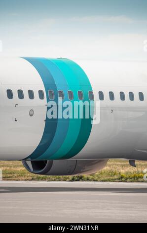 Image verticale de la section du fuselage avec quatre anneaux bleu sarcelle. Vue rapprochée d'un avion stationné sur l'aire de trafic - fuselage d'un avion de passagers. Banque D'Images