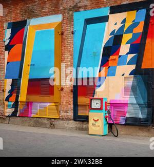 street art sur le mur de la vieille usine. façade d'usine de briques avec peinture murale géométrique conceptuelle dessus Banque D'Images