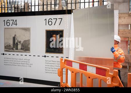 Un entrepreneur complète une palissade protectrice qui montre le visage de Samuel Pepys et les dates historiques du 12ème siècle L'église All Hallows est entourée par l'activité de construction moderne dans la ville de Londres, le quartier financier de la capitale, le 28 février 2024, à Londres, en Angleterre. Toutes les taches de reliefs (qui signifie construit à partir de pierre, pas de bois) ont survécu au Grand incendie de Londres en 1666 et malgré de lourds dommages, au Blitz de la seconde Guerre mondiale. Le site situé au 50 Fenchurch comprend actuellement la coloration de la tour de tous les reliefs classée Grade I et la crypte de la chapelle Lambe classée Grade II, mais la construction i. Banque D'Images