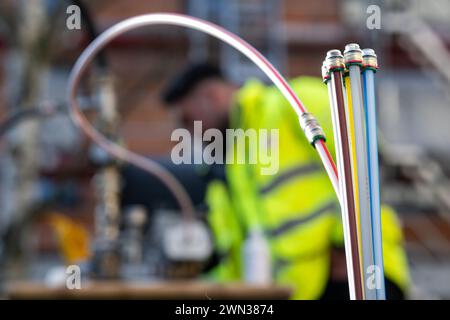 Berlin, Allemagne. 29 février 2024. Des conduits vides pour câbles à fibres optiques dépassent d'une fosse lors d'une démonstration de la pose de câbles à fibres optiques sur un chantier de construction de la coopérative immobilière de Charlottenburg. Berlin vise à avoir 2,2 millions de foyers et d'entreprises connectés au réseau de fibre optique d'ici 2028. Crédit : Sebastian Christoph Gollnow/dpa/Alamy Live News Banque D'Images