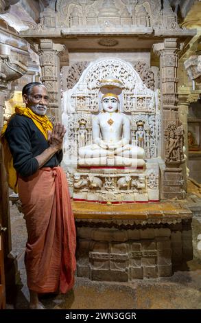 Jaisalmer, Inde - 12 février 2024 : homme en prière devant une statue de buhhda Chandraprabha ou Seigneur de la Lune au temple Jaïn à Jaisalmer, Inde. Banque D'Images