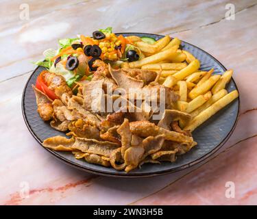 Assiette Chicken Shawarma avec salade, frites servies dans un plat isolé sur fond gris vue latérale de l'arabian fastfood, majorque, îles baléares, espagne Banque D'Images