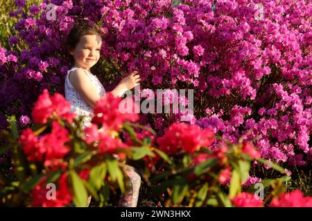 13/03/14 Maggie Welsh, 6 ans, s'émerveille devant les rhododendrons fleurissant plus de deux semaines plus tôt que d'habitude à Lea Gardens près de Matlock, Derbyshire. Tous Banque D'Images