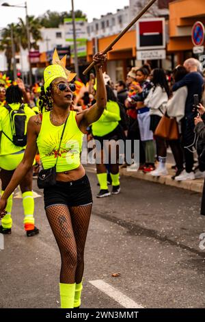 Un groupe d'individus portant des chemises jaunes et vert fluo défilant dans une rue de la ville, Carnaval de Montpellier Banque D'Images