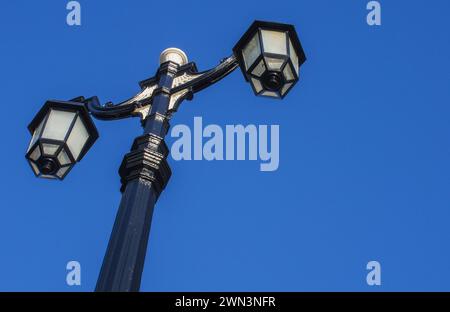 ECLAIRAGE de rue à l'ancienne avec doubles lampes contre le ciel bleu Banque D'Images