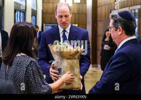 Le prince de Galles reçoit un bouquet de fleurs pour sa femme Catherine, princesse de Galles, lors d'une visite à la synagogue Western Marble Arch de Londres. Date de la photo : jeudi 29 février 2024. Banque D'Images