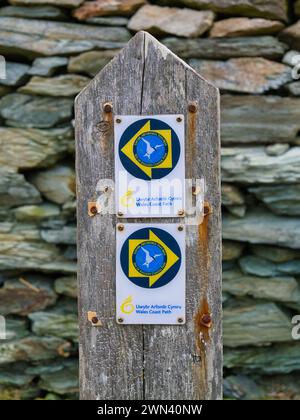 Anglesey, Royaume-Uni - 11 janvier 2024 : un panneau en bois altéré indiquant la voie pour les marcheurs sur le Wales Coast Path sur l'île Anglesey dans le nord du pays de Galles Banque D'Images