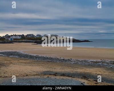 Trearddur Bay, Royaume-Uni - 11 janvier 2024 : un couple non identifié marche sur une plage de Traeth Trearddur - Trearddur autrement déserte en hiver Banque D'Images