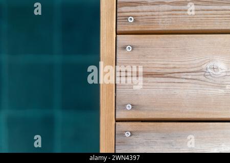 Terrasse en bois au bord de la piscine et fond d'eau bleu foncé Banque D'Images