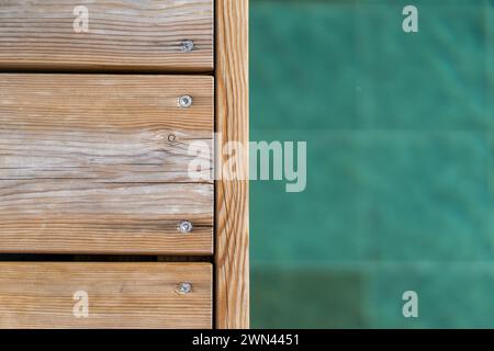 Terrasse en bois au bord de la piscine et eau bleu turquoise de fond de luxe de piscine. Banque D'Images