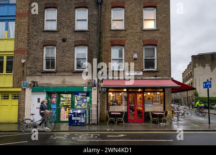 Bermondsey, Londres, Royaume-Uni : petite boutique et restaurants sur Bermondsey Street dans le quartier londonien de Southwark avec deux cyclistes. Banque D'Images