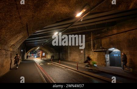 Southwark, Londres, Royaume-Uni : Bermondsey Street passant par un tunnel sous le London Bridge jusqu'au viaduc ferroviaire de Greenwich avec cyclistes et piétons. Banque D'Images