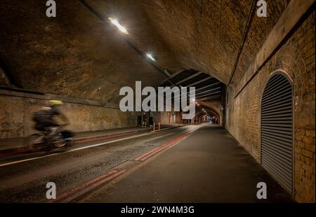 Southwark, Londres, Royaume-Uni : Bermondsey Street passant par un tunnel sous le London Bridge jusqu'au viaduc ferroviaire de Greenwich avec cyclistes et piétons. Banque D'Images