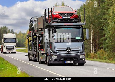 Silver Mercedes-Benz Actros 2443 camion de transport de véhicules transporte des voitures sur l'autoroute 25, MG voiture à l'avant. Raasepori, Finlande. 8 septembre 2023. Banque D'Images