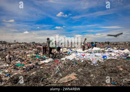 Les collecteurs de déchets récupèrent les produits recyclables à la décharge. Le bidonville de Dandora abrite l'une des plus grandes et des plus connues décharges de Dandora. Le site de 30 acres avec une estimation de 850 déchets solides générant de partout à Nairobi a été fondé en 1975. Chaque minute, les récupérateurs de déchets sur le site déchargent les déchets de différents camions arrivant sur le site. Les ramasseurs de déchets qui sont également résidents de différentes parties de la région dépendent de la décharge comme source de revenus grâce au recyclage des déchets tels que les déchets plastiques, les bouteilles en verre et les produits mentaux. Mais brûler des déchets sur le site le Banque D'Images