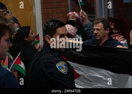 Bakersfield, Californie, États-Unis. 28 février 2024. Un policier de Bakersfield tient fermement contre un groupe d’activistes pro-palestiniens qui ont été expulsés des salles du conseil municipal le 28 février 2024, après avoir perturbé la procédure avec des chants et des slogans visant le maire Karen Goh et le vice-maire Andrae Gonzales. (Crédit image : © Jake Lee Green/ZUMA Press Wire) USAGE ÉDITORIAL SEULEMENT! Non destiné à UN USAGE commercial ! Banque D'Images