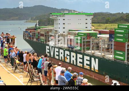 Canal de Panama, Panama - 23 janvier 2024 : passagers sur le pont supérieur d'un navire de croisière regardant un porte-conteneurs de passage Banque D'Images