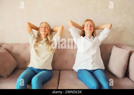 Détendu heureux caucasien mère d'âge moyen et fille adulte se reposant ensemble, les femmes assis sur le canapé à la maison Banque D'Images