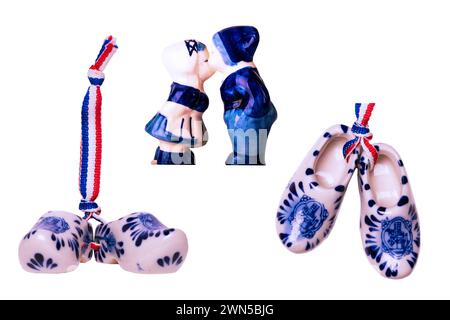 Chaussures en porcelaine hollandaise traditionnelles avec un drapeau ruban et embrasser garçon et une fille en costumes hollandais traditionnels isolés. Sabots en bois Holland. Souvenir Banque D'Images