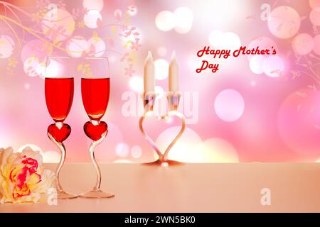 Bonne carte de fête des mères. Deux verres de champagner, un bouquet de fleurs sur la table sur fond de coeur abstrait avec inscription Happy Mothers. Copier spac Banque D'Images