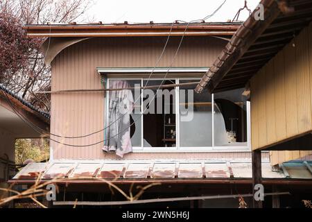 Namie, Fukushima, Japon. 27 février 2024. Une maison abandonnée est vue dans la ville de Namie, préfecture de Fukushima. La centrale nucléaire de Fukushima Daiichi a connu une catastrophe nucléaire, provoquant l'évacuation de milliers de résidents après le tremblement de terre de l'est du Japon et le tsunami qui a suivi ont dévasté les préfectures de Miyagi, d'Iwate et de Fukushima. Dix ans après la levée de l'ordre d'évacuation du district de Miyakoji dans la ville de Tamura, la première zone à avoir levé les restrictions dans un rayon de 20 kilomètres de la centrale nucléaire de TEPCO à Fukushima marque une étape importante Banque D'Images