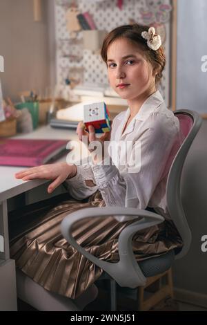 Ekaterinbourg, Russie, 14 février 2024 : fille mignonne à la maison résolvant un cube de rubik. Il a été inventé par l'architecte hongrois Erno Rubik en 1974. Banque D'Images