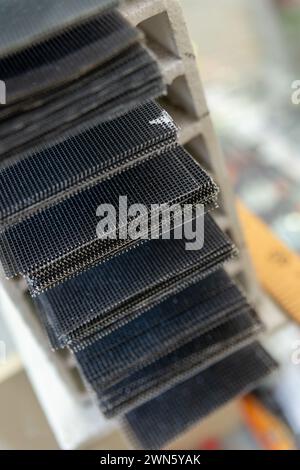 Grille de meulage de différentes tailles de grains sur la fenêtre d'un magasin de matériaux de construction. Mise au point sélective. Banque D'Images