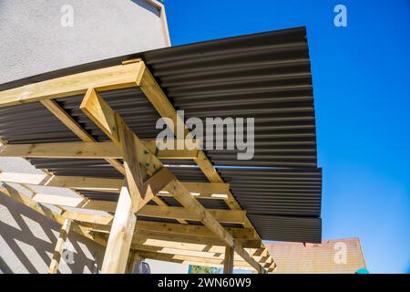 Couvrant le toit sur des poutres en bois pour un gazebo, le fond d'un ciel bleu Banque D'Images