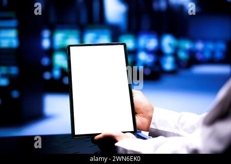 Spécialiste utilisant une tablette maquette pour effectuer la maintenance des serveurs aidant les entreprises à gérer les bases de données. Technicien surveillant les supercalculateurs utilisés pour le calcul haute performance, gros plan Banque D'Images