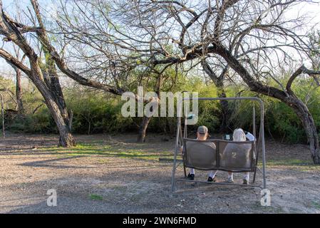 Couple âgé assis dans une chaise pour deux personnes à une station d'observation des oiseaux dans le Bentsen-Rio Grande Valley State Park, Mission, Hidalgo County, Texas, États-Unis. Banque D'Images