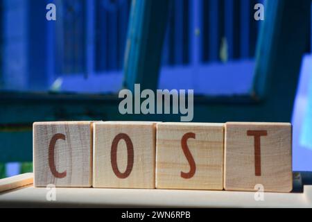 Les blocs de bois composent le mot 'COST' en anglais. Bloc de bois Banque D'Images