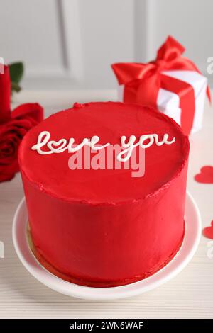 Bento gâteau avec texte Love You, roses et boîte cadeau sur table en bois blanc, gros plan. Prog Surprise pour la Saint-Valentin Banque D'Images